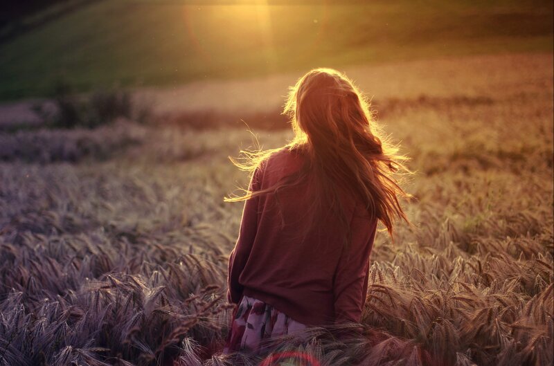 Woman in a wheat field at sunset