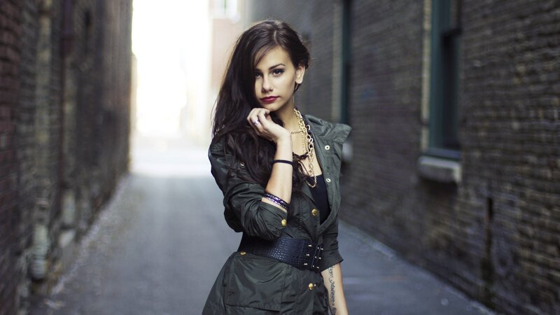 woman in alleyway wearing green jacket