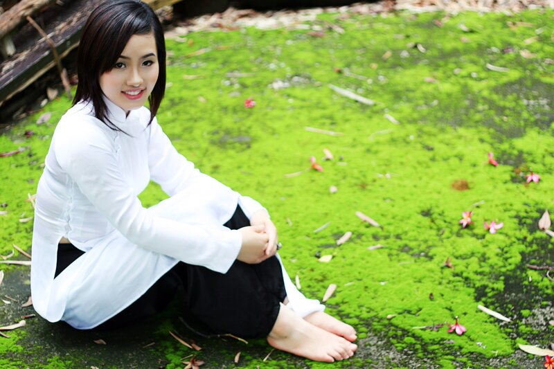 woman in ao dai sitting on moss