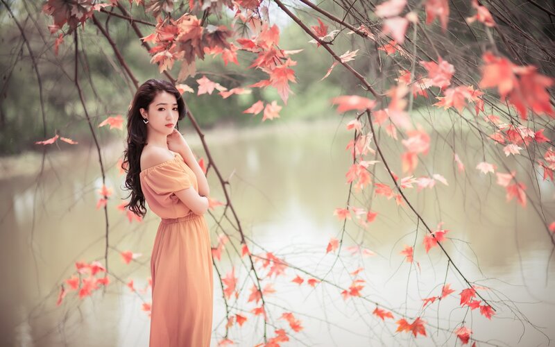 woman in autumn dress by lake
