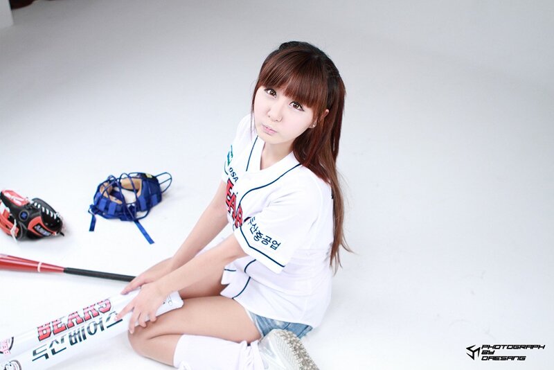 woman in baseball uniform sitting