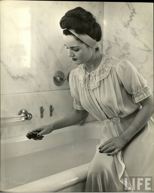 woman in bathrobe by bathtub