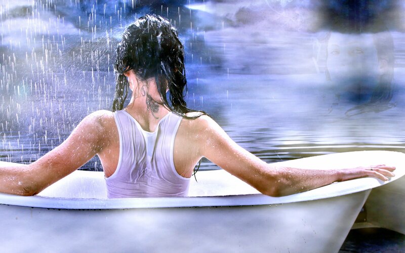 woman in bathtub under rain