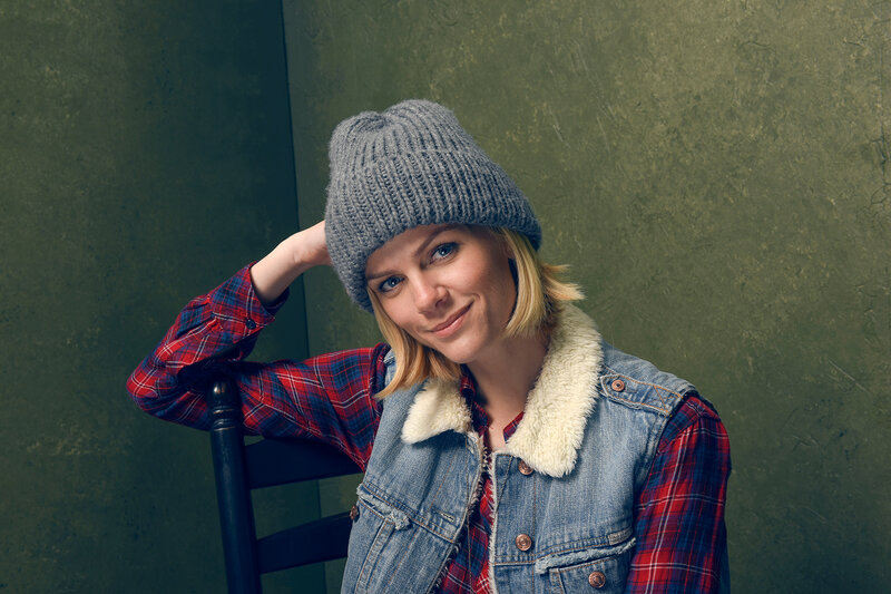 woman in beanie and denim vest