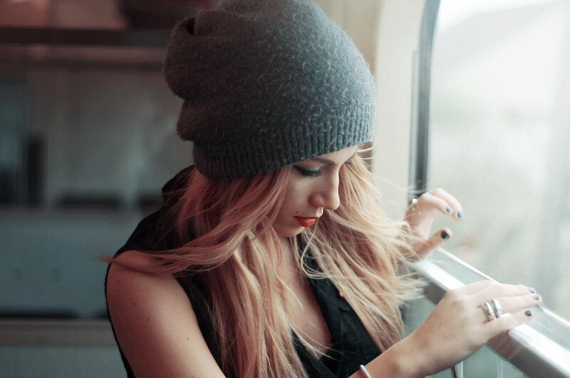 woman in beanie by window