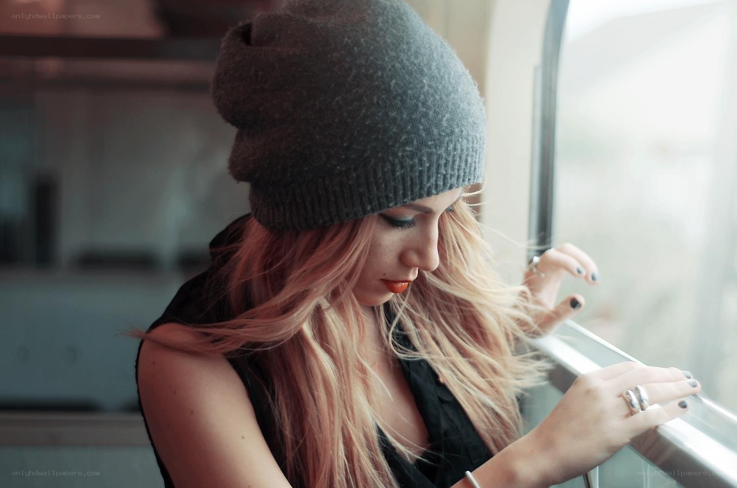 woman in beanie by window