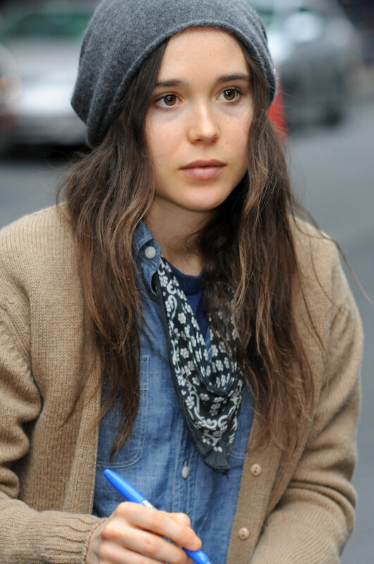 woman in beanie holding pen