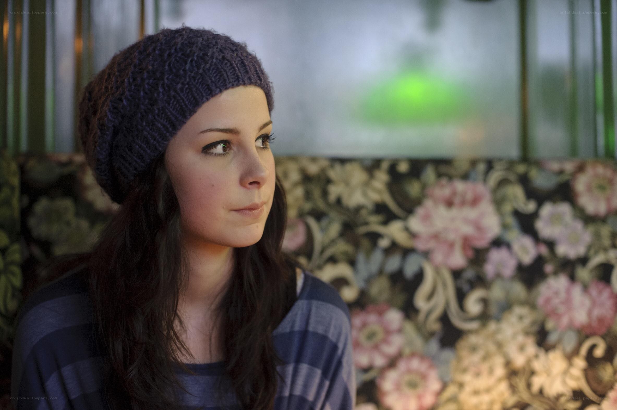 woman in beanie looking out window