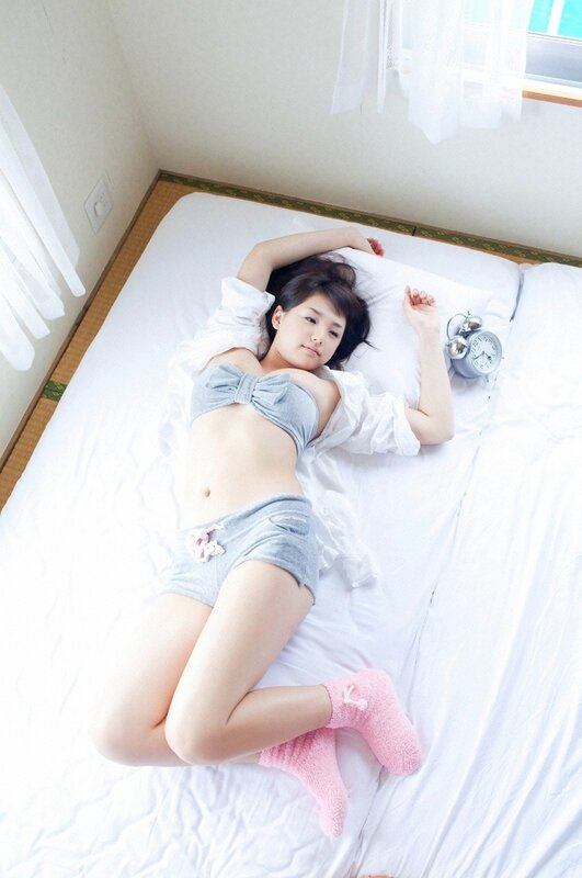 woman in bed with alarm clock