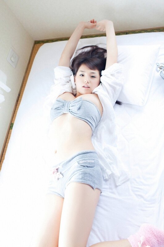 woman in bed with arms raised