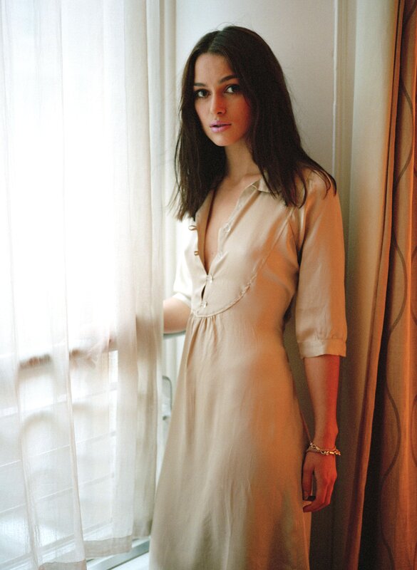 woman in beige dress by window
