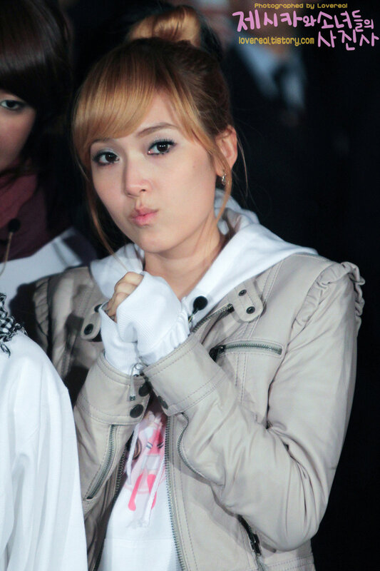woman in beige jacket making a face