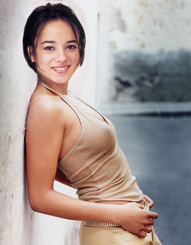 woman in beige top leaning on wall