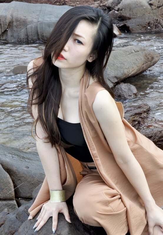 woman in beige vest by river