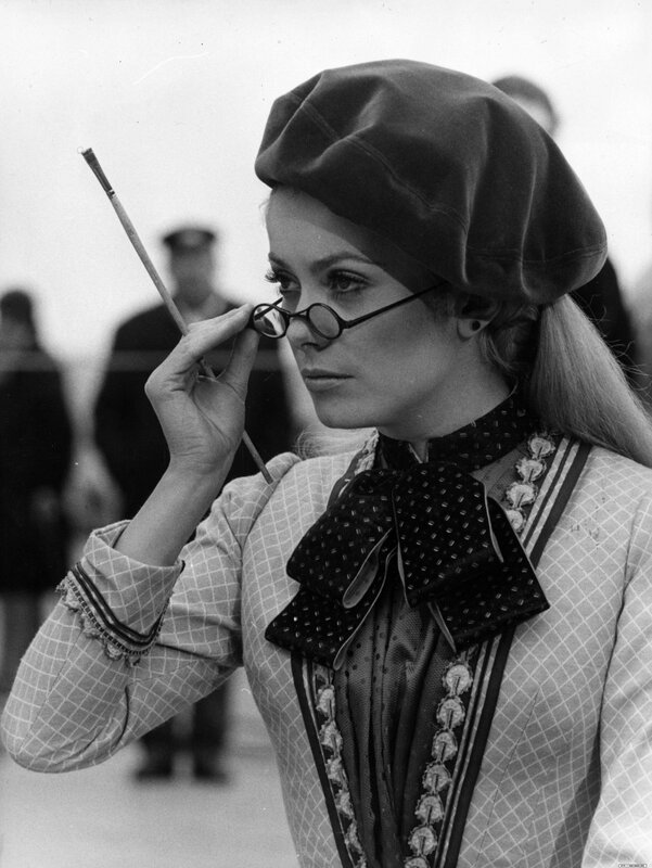 woman in beret holding paintbrush