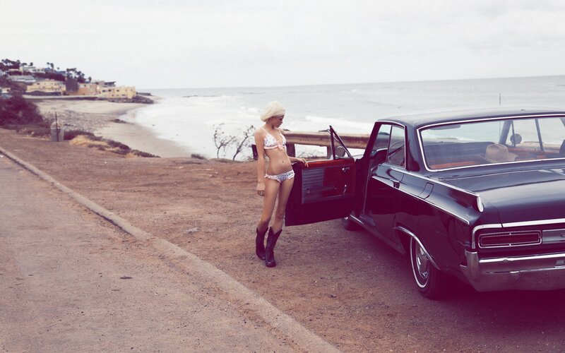 woman in bikini by car at beach