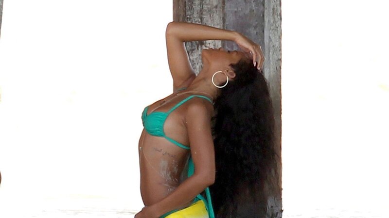 woman in bikini leaning against pillar