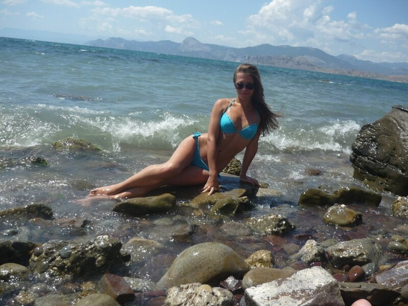 Woman in bikini on rocky beach