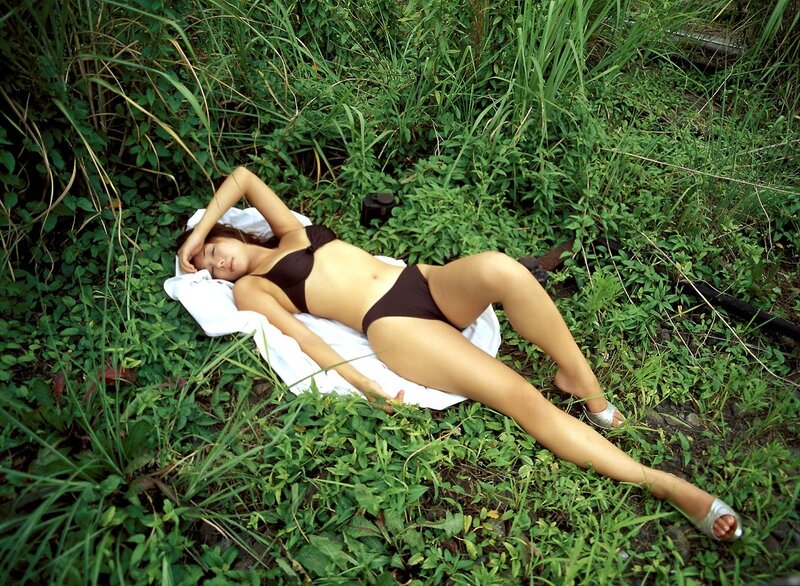 Woman in bikini resting on grass