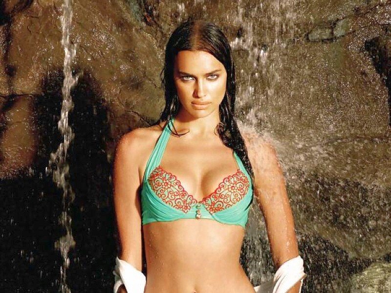 woman in bikini under waterfall