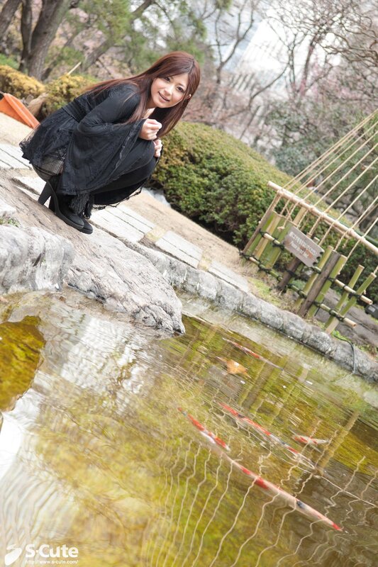 Woman in black at a koi pond