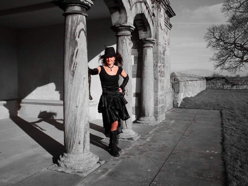 Woman in black attire at stone structure