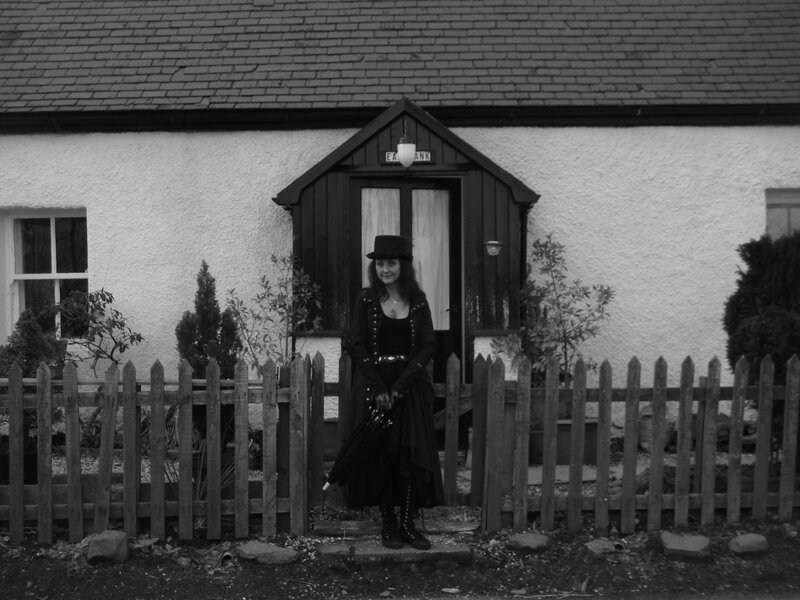 woman in black attire outside cottage