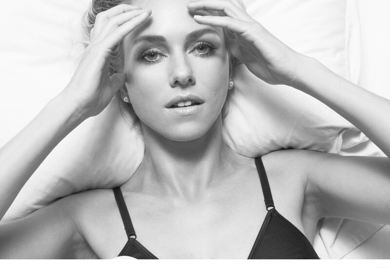 woman in black bra lying on bed