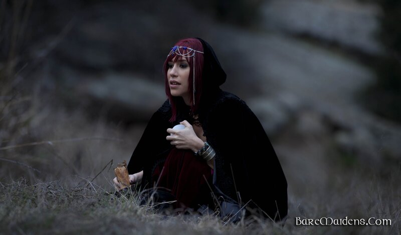 woman in black cloak holding object
