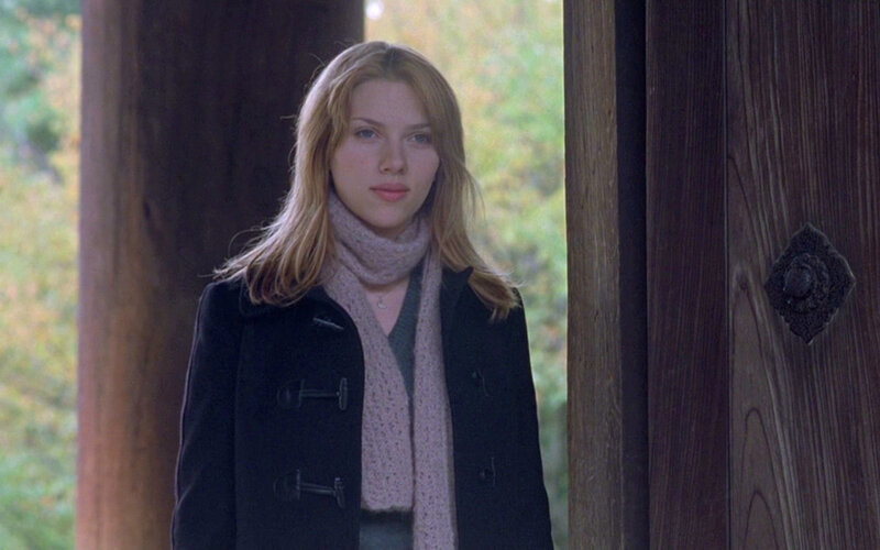 woman in black coat standing