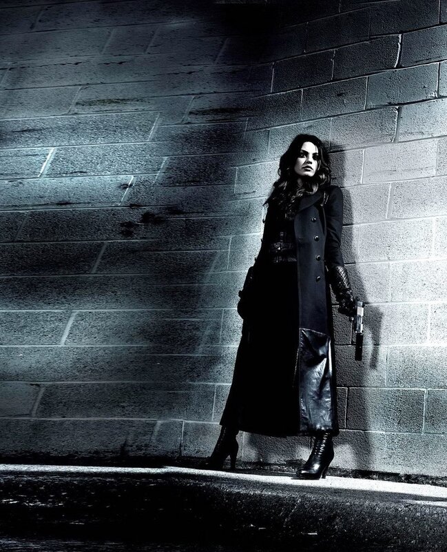 woman in black coat with gun