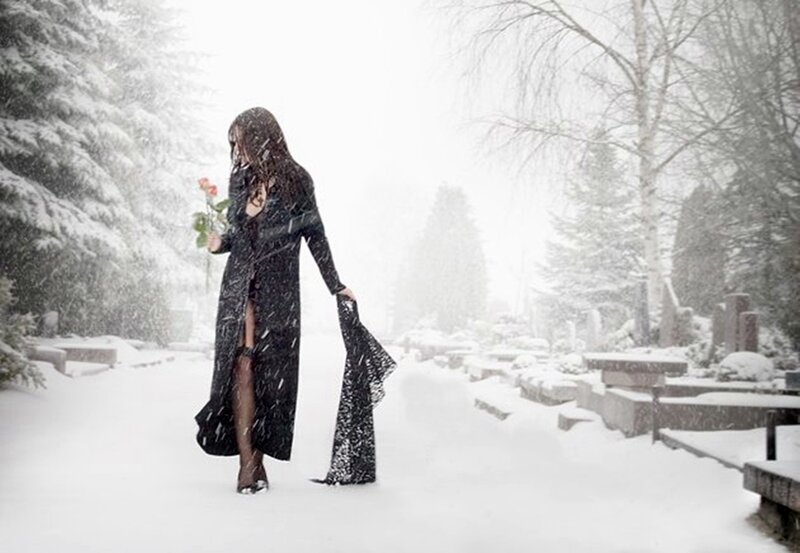 Woman in black coat with rose