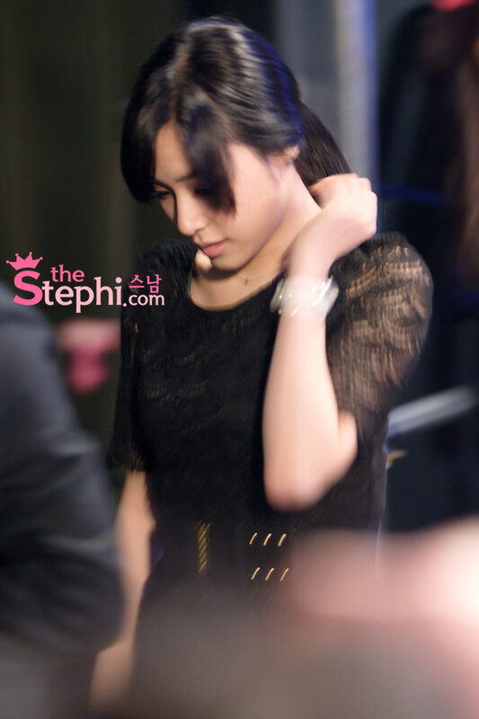 woman in black dress adjusting hair