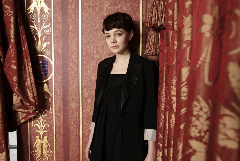 woman in black dress against red curtain
