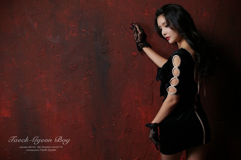 woman in black dress against red wall