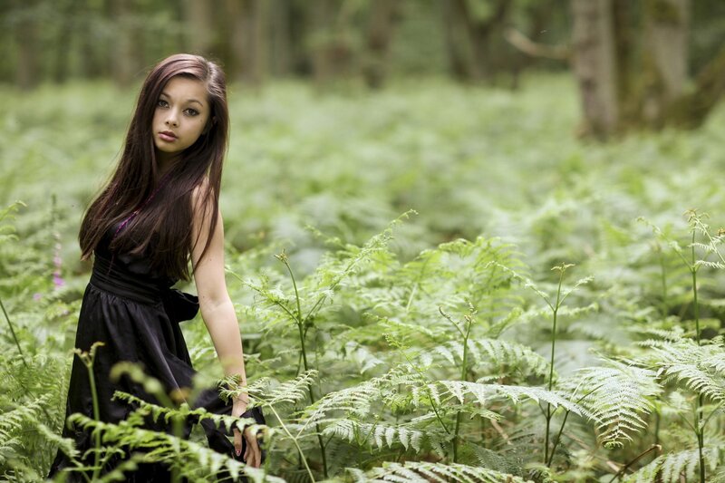 woman in black dress among ferns