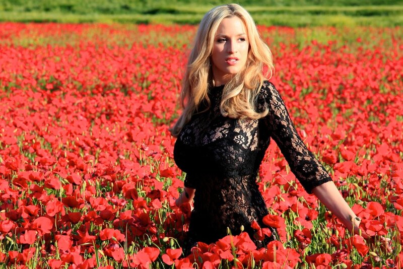 woman in black dress among poppies