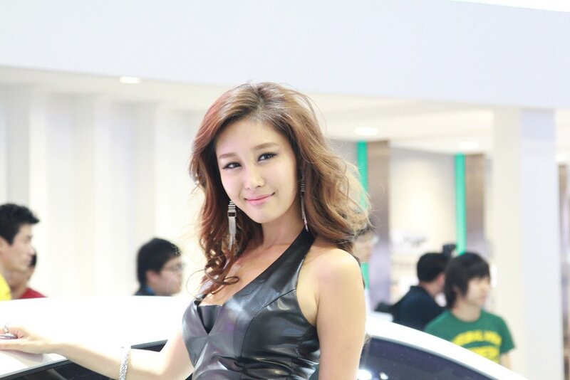 woman in black dress at auto show