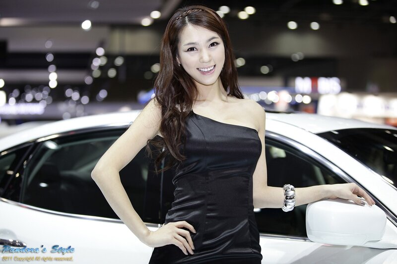 Woman in black dress at car show