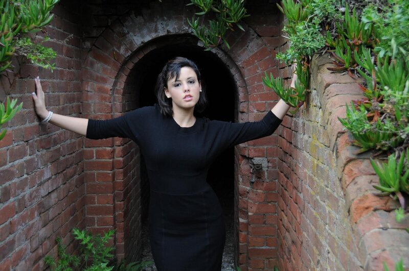 woman in black dress at tunnel entrance