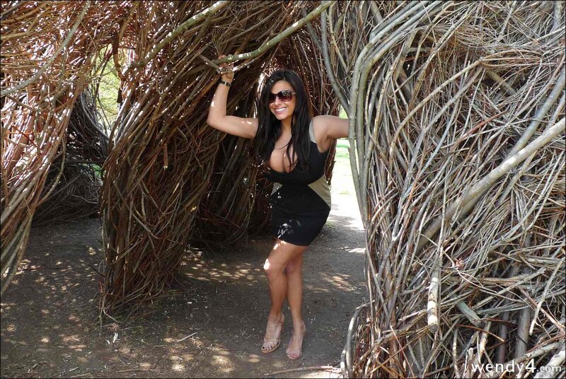 Woman in black dress at twig structure