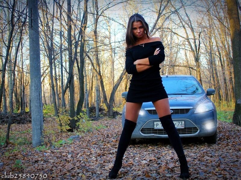 Woman in black dress by car
