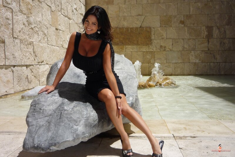 Woman in black dress by fountain