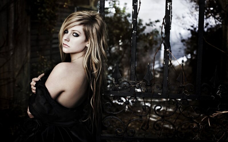 Woman in black dress by gate