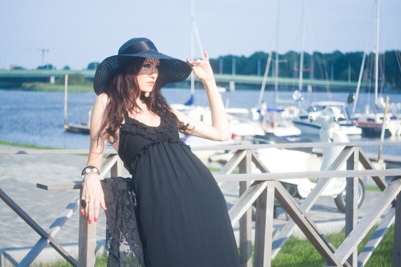 Woman in black dress by the harbor
