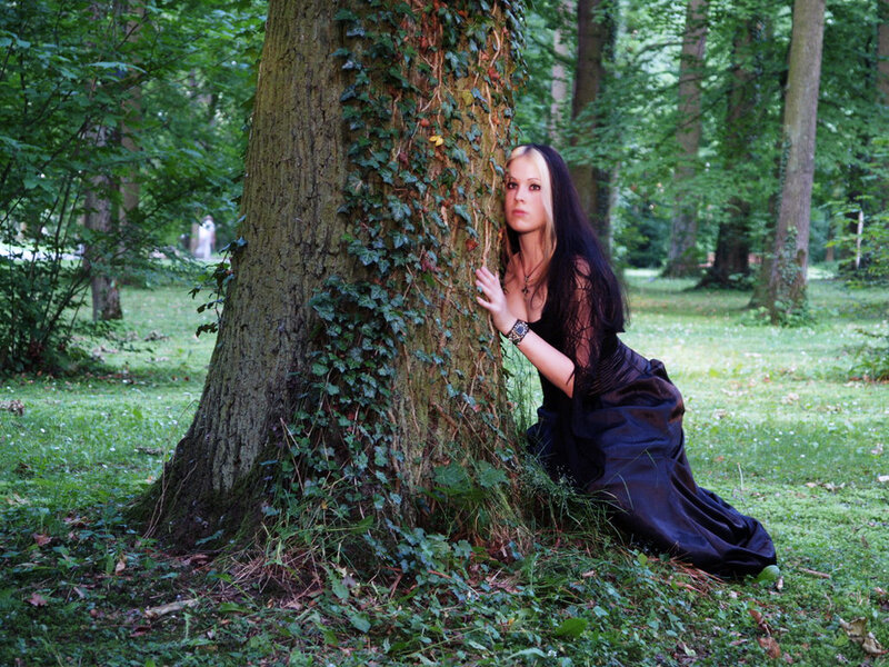 Woman in black dress by tree