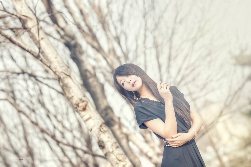 woman in black dress by trees