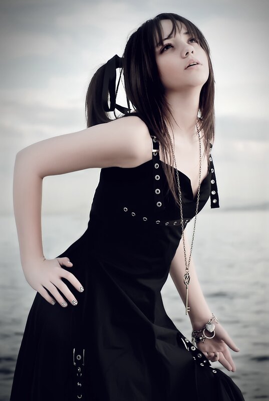 woman in black dress by water