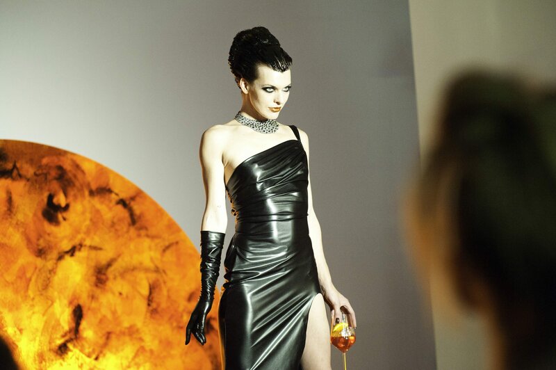 Woman in black dress holding drink