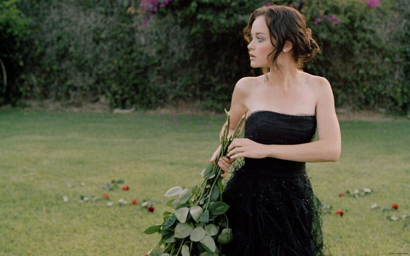woman in black dress holding flowers